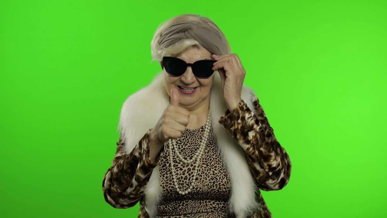 Anziana donna caucasica in stile retrò indossa occhiali da sole. Sfondo chroma key