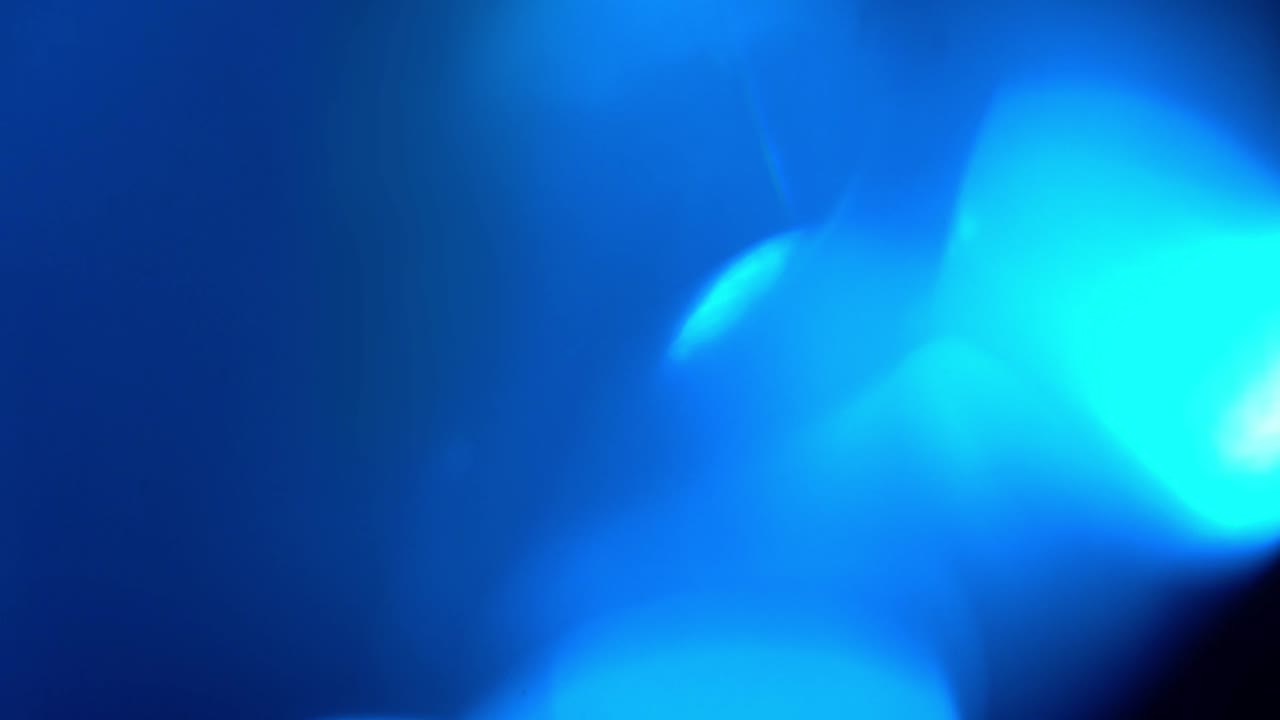 Fughe di luce blu astratte e bagliori dell'obiettivo su sfondo scuro