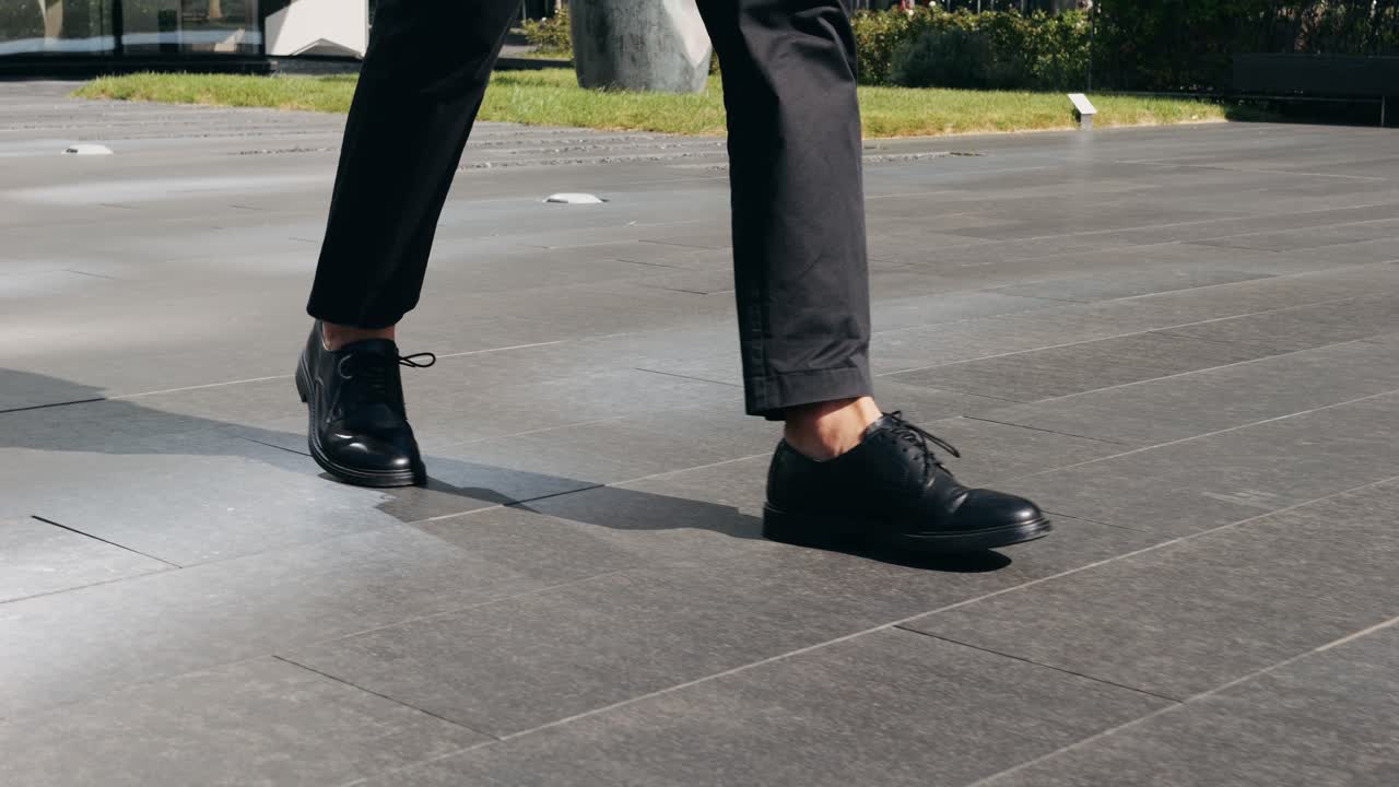Person walking in black shoes