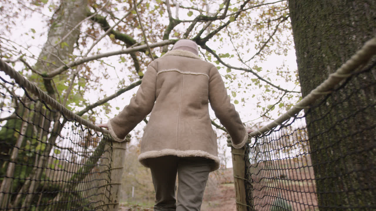 숲에서 자연 다리를 건너 여성