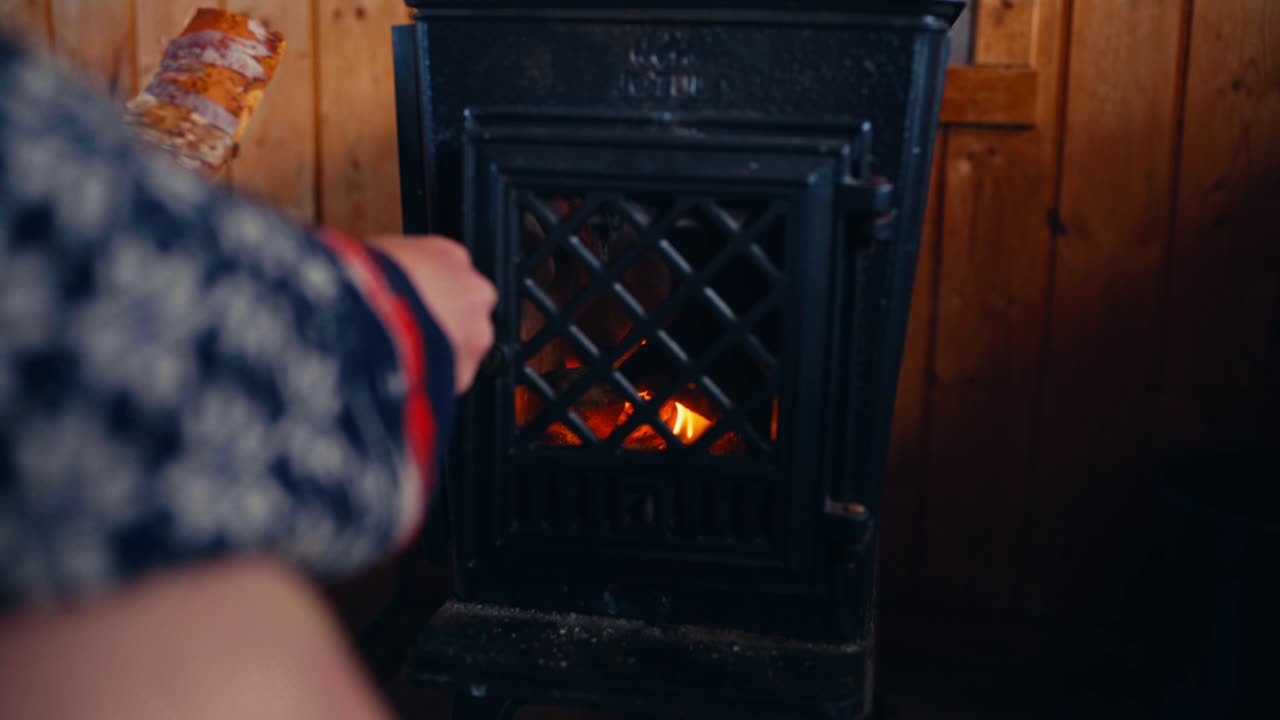 A Man Sits in Front of a Warm Fire Inside a Cabin Near Reinsjøen in Åfjord, Trøndelag, Norway - Close Up