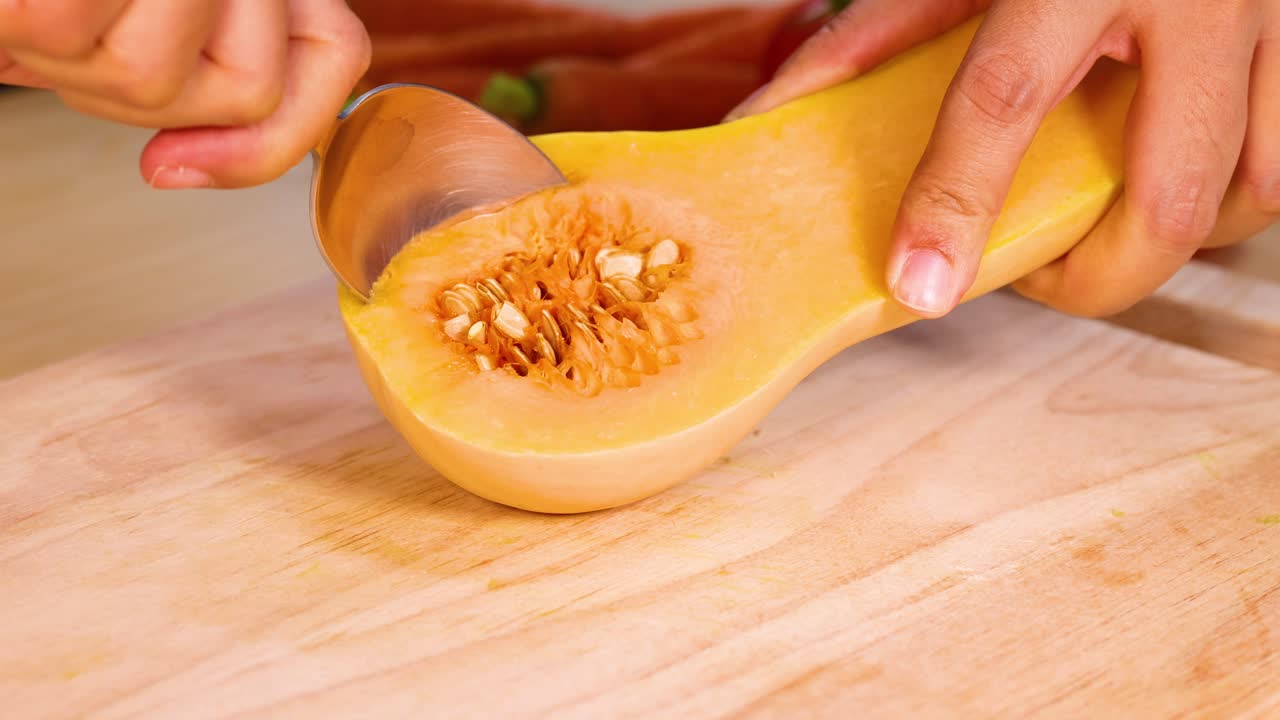 Scooping seeds from a butternut squash