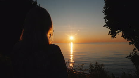 woman tourist admires the sunset over the sea in the tropics