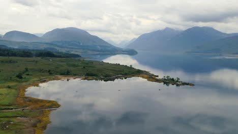 Slow-motion-shot-of-the-beautiful-scenario-of-the-empty-island-near-the-mountain-range-at-evening-in-a-natural-background-of-Glen-Coe,-Loch-Etive-at-Scotland