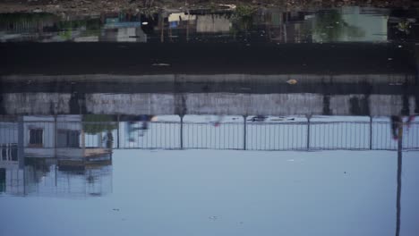 reflection of motorbikes riding across a bridge in polluted water