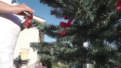 manos femeninas negras decorando el árbol de navidad