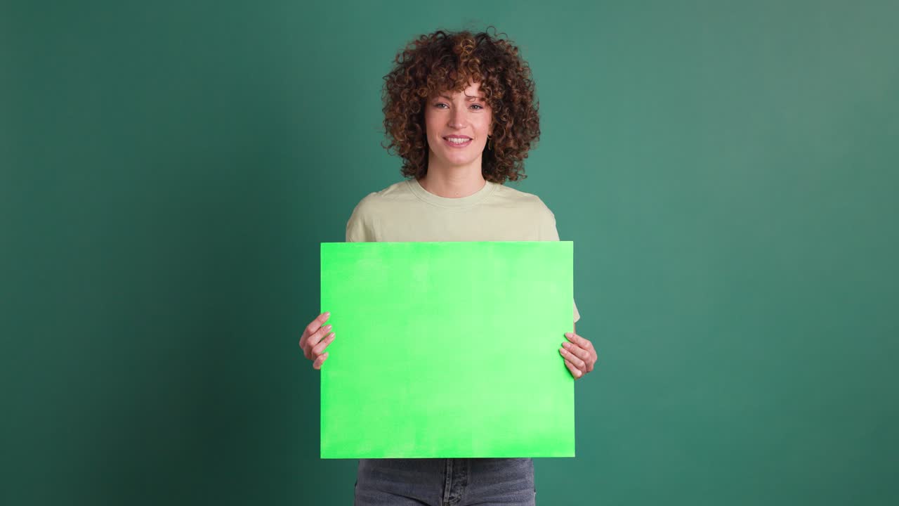 Happy woman holding chroma sign banner in green background