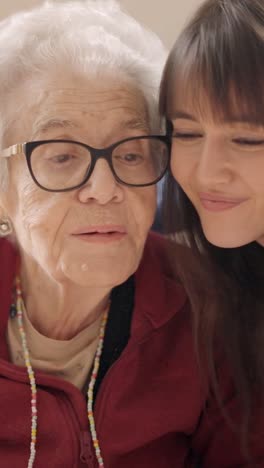 granddaughter embracing and kissing her grandmother in a geriatric