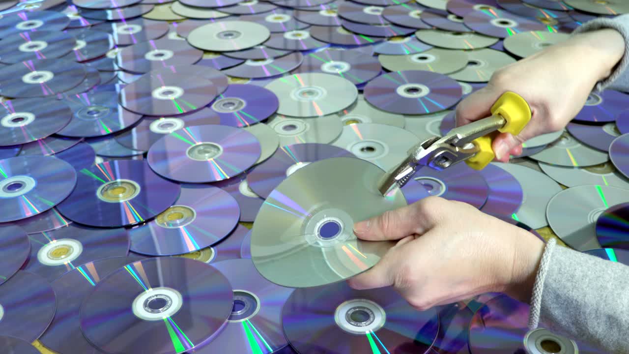 Woman destroying CD and DVD discs