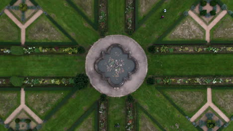 Toma-Aérea-De-Simetría-Absoluta-De-Un-Parque-Francés-Con-Una-Fuente