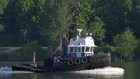 emergency towing vessel sailing across fraser river in new westminster, british columbia, canada