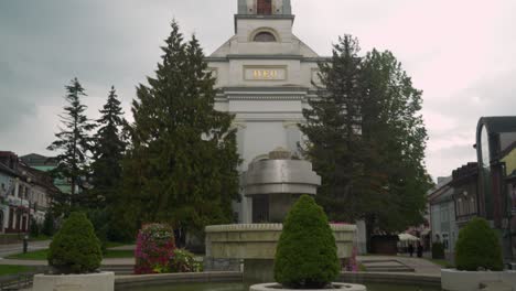 fountains in the middle of town shot revealing a church