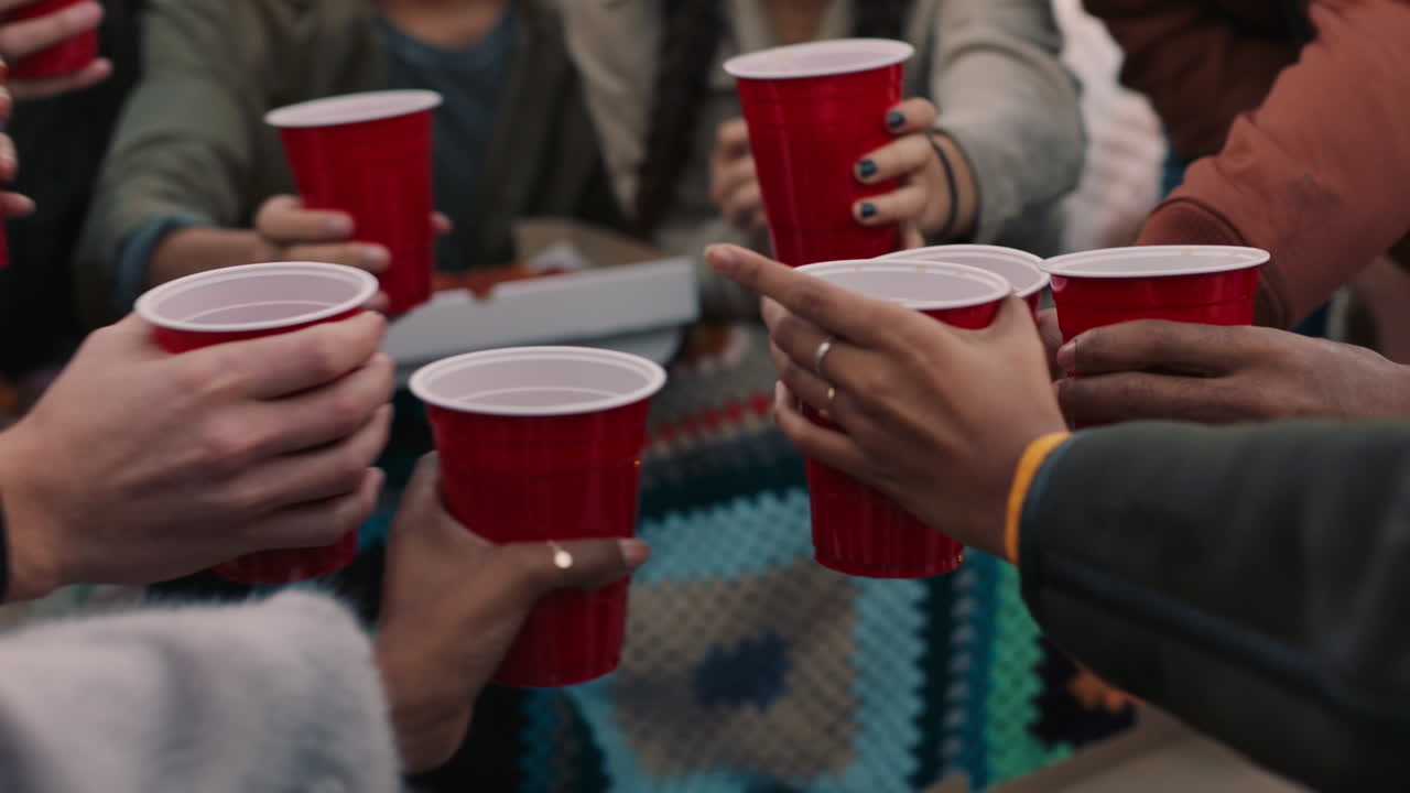 un gruppo di amici che bevono alcol, fanno un brindisi, si divertono sul tetto, si riuniscono, si divertono, chiacchierano, condividono la pizza al tramonto.