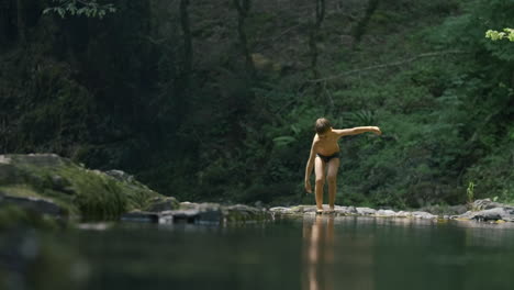 boy playing in a forest creek