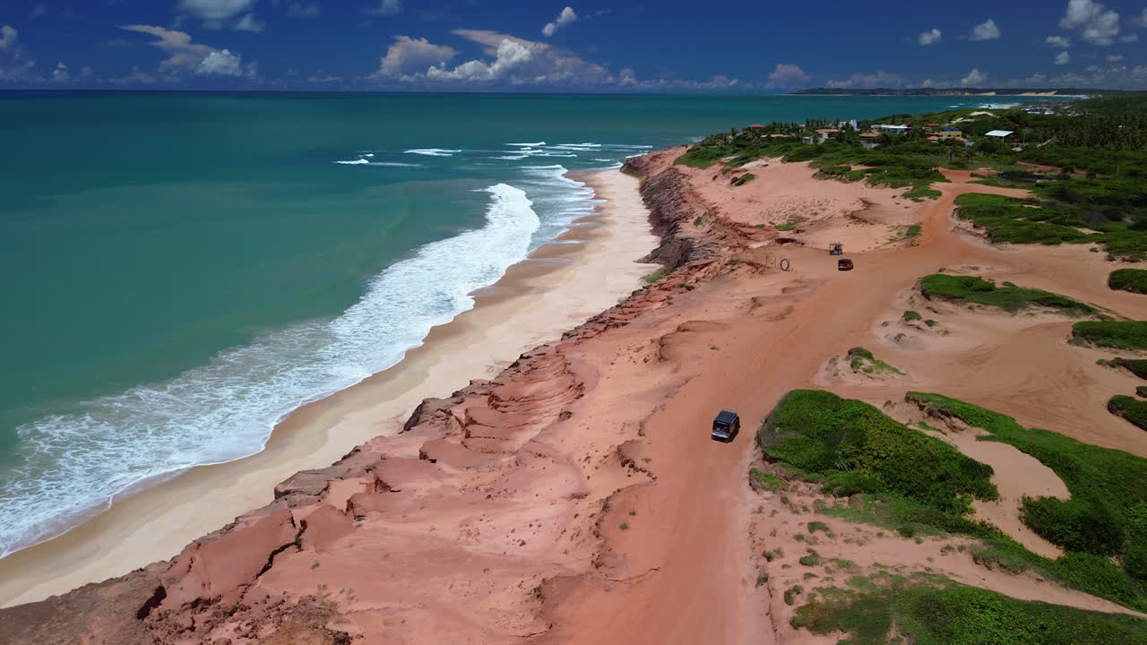 vista aérea siguiendo un jeep 4x4 conduciendo en la costa de chapadao, brasil soleado
