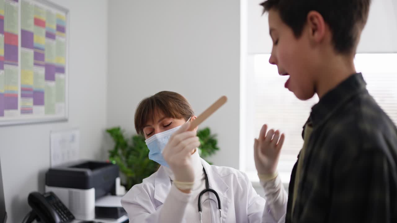 아이의 목을 검사하는 의사