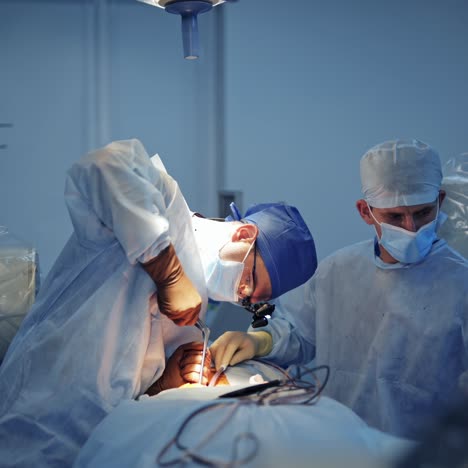 surgical procedure in clinic. young medical worker assists surgeon during operation in the operating room. doctor uses sterile instruments. healthcare concept.