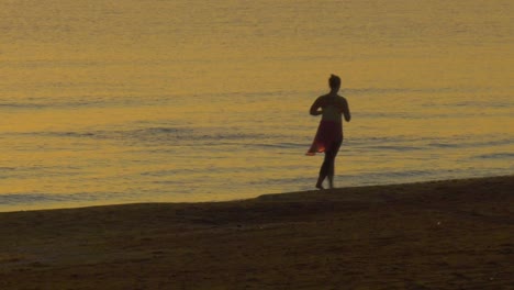 Frau-Joggt-Bei-Tagesanbruch-Am-Strand-Neben-Ruhigem-Meer