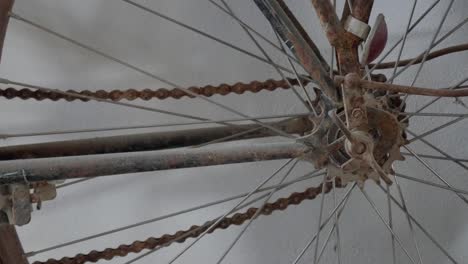 zoom out of a vintage rusty bicycle wheel with old chain and spokes in detail