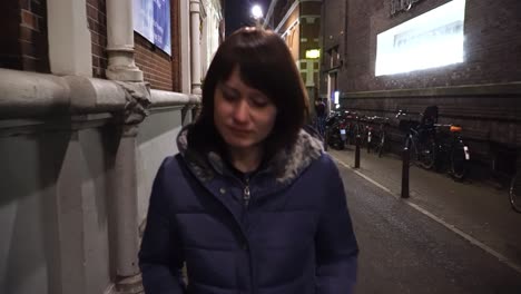 caucasian woman walks on street evening. young female traveler