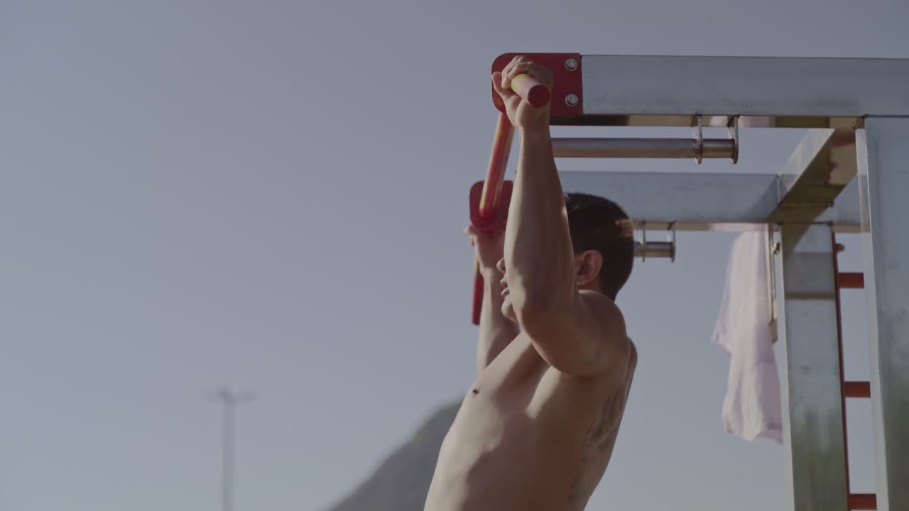 야외 체육관 에서 풀업 을 하는 남자