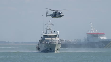 german nh90 navy helicopter hoisting a person from a naval vessel