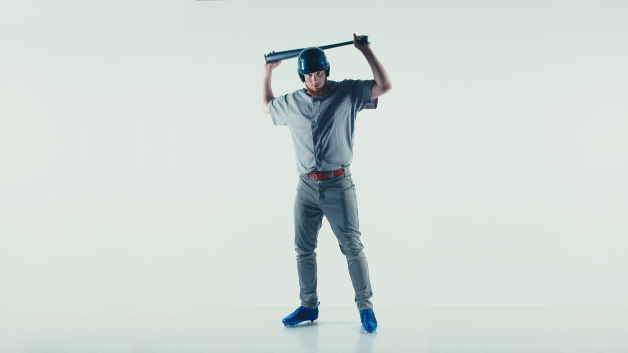 백인 프로 야구 선수, 일반 유니폼을 입은 타자, 색 배경에 고립된 공을 때리는 4k uhd 60fps 느린 동작