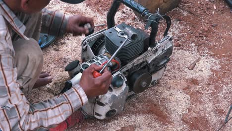 Man-Fixing-a-Chainsaw-on-the-Floor