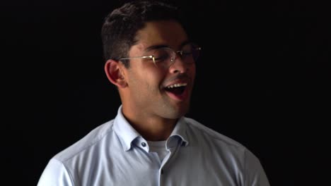 Happy-Man-In-Glasses-Smiles-At-Camera-On-Black-Background