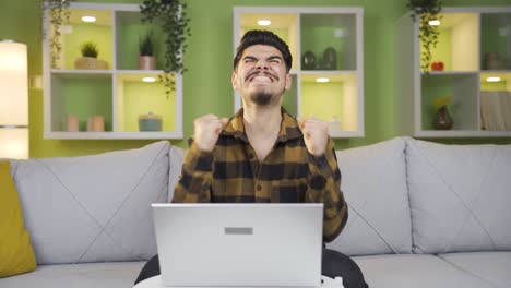 el hombre que trabaja en la computadora portátil está contento con las noticias que recibió.