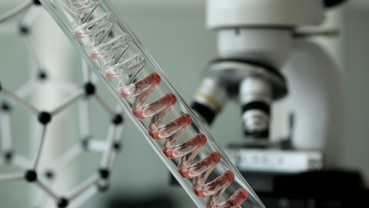 Red liquid flowing through sterile glass tube in laboratory