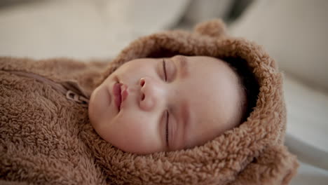 adorable baby sleeping in a teddy bear onesie