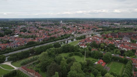 fotografía aérea de un molino de viento en bruges, bélgica, con viejos edificios y canales