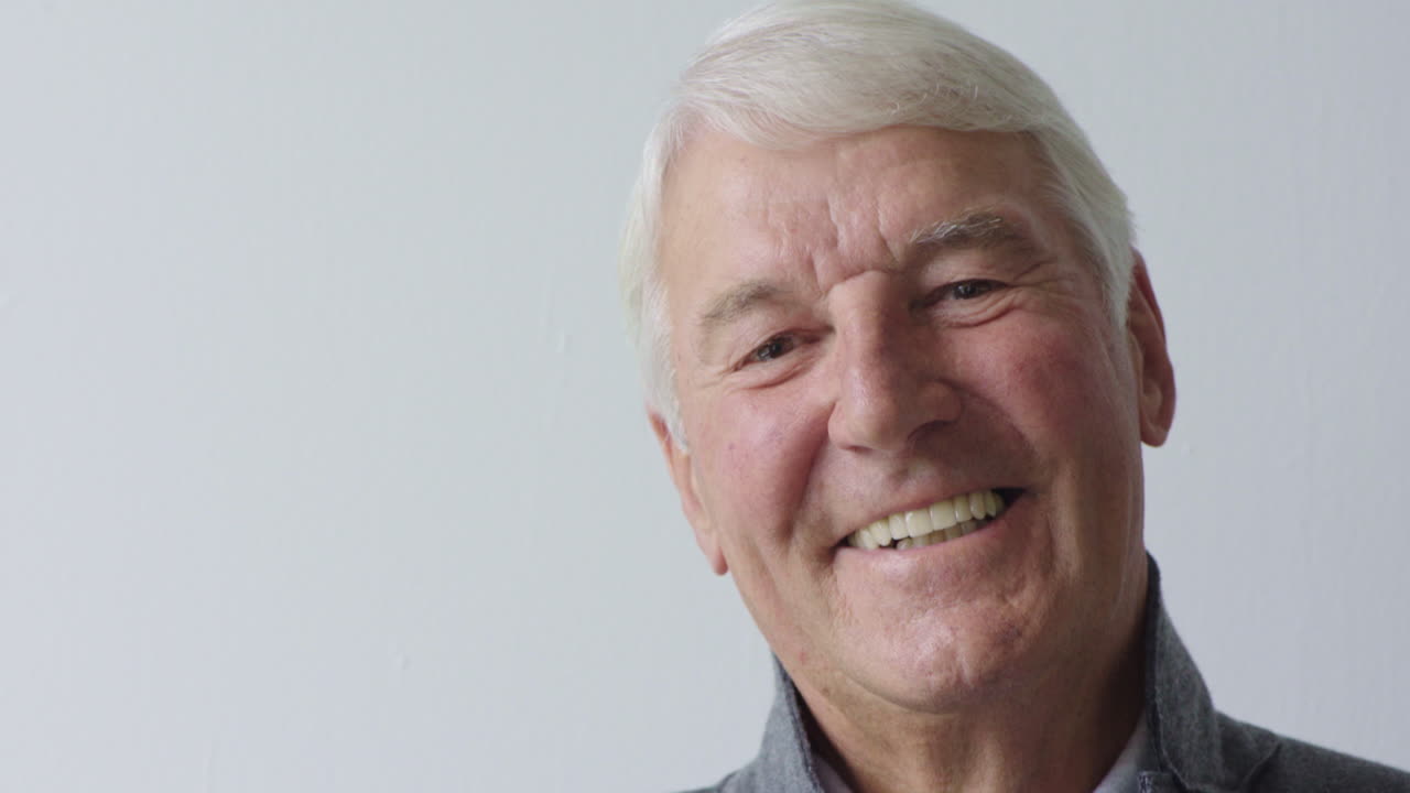 portrait of happy elderly man smiling enjoying successful retirement lifestyle satisfaction looking at camera isolated on white background
