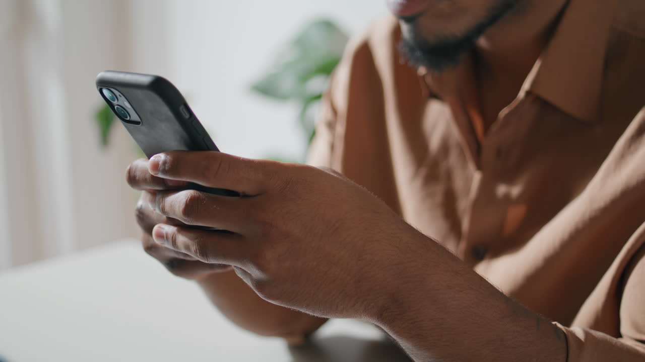 Closeup mobile phone in man hands at flat. Guy hands messaging smartphone