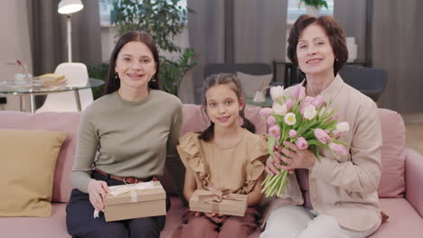 three generations of women with gifts and flowers