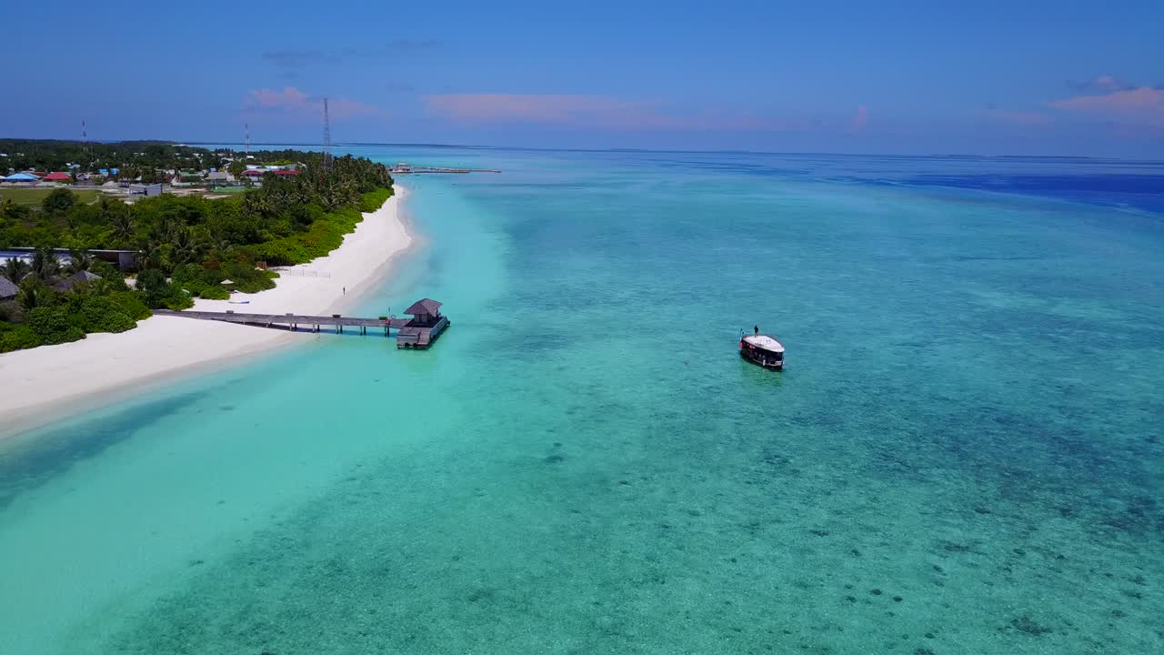 vista aérea de um pequeno porto de um resort no mar do caribe e um barco está esperando à toa