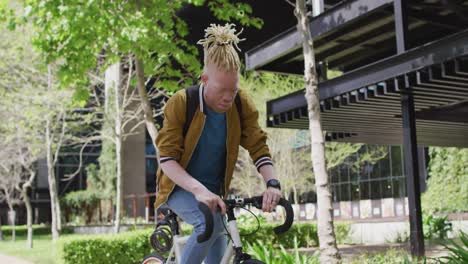 Glücklicher-Afroamerikanischer-Albino-Mann-Mit-Dreadlocks,-Der-Fahrrad-Fährt