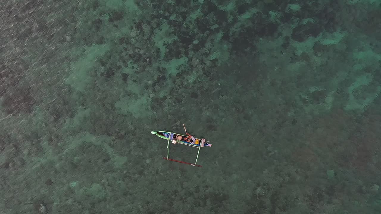 인도네시아 롬복에 위치한 핑크 해변에서 보트를 타는 어부의 공중 전망 - 공중 촬영