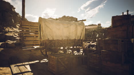 old wooden wagon covered with canvas in a dusty settlement under the sun