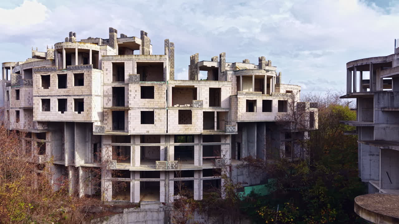 Exploring the haunting beauty of abandoned concrete structures in a forgotten urban landscape under a cloudy sky