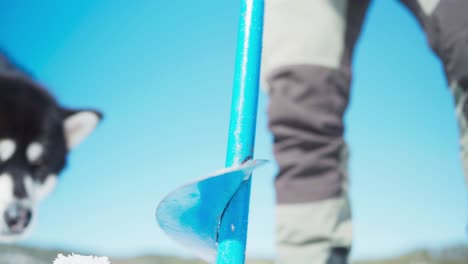 ice auger drilling hole on frozen lake