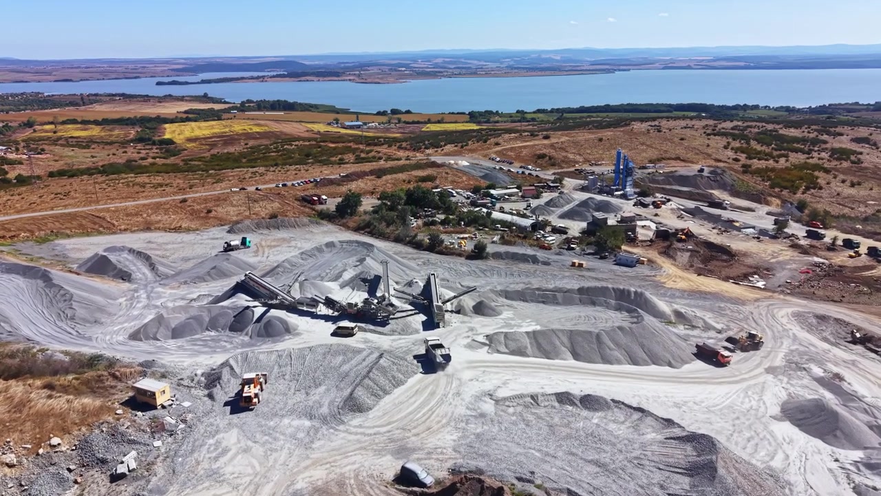 Granite quarry at work with machinery and rock formations under a clear sky