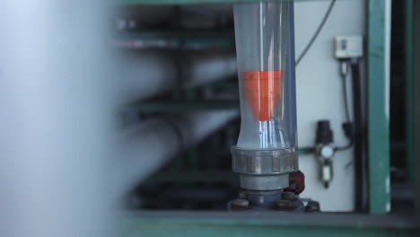 la toma panorámica revela un tubo de vidrio en una máquina enorme que indica el nivel de calor del proceso en la fábrica de aceite de palma
