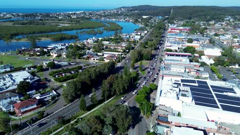 Landscape-view-of-cars-driving-down-roads-street-main-town-Swansea-rural-suburb-of-NSW-Australia-highway-shops-infrastructure-lagoon-lake-drone-aerial-travel-Belmont