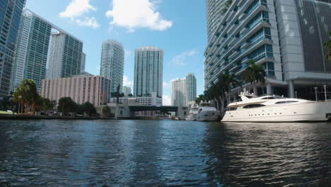 Vista-Desde-Una-Pequeña-Embarcación-Mientras-Viaja-Por-Las-Vías-Fluviales-Costeras-En-Miami,-Florida,-Con-Edificios-Altos-Y-Yates