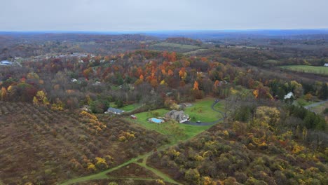 Flug-über-Ein-Herbstliches-Tal-Mit-Laubbäumen-Und-Einer-Wohngegend