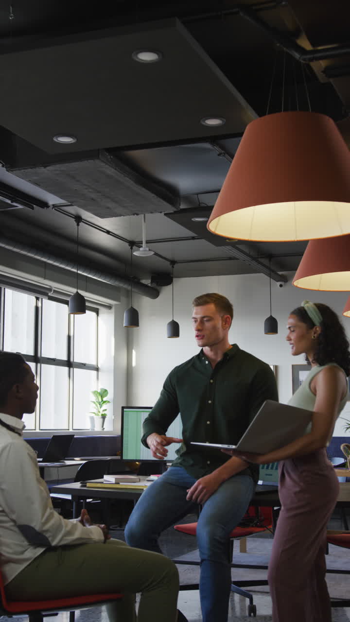 video vertical de personas de negocios felices y diversas discutiendo el trabajo durante una reunión en la oficina