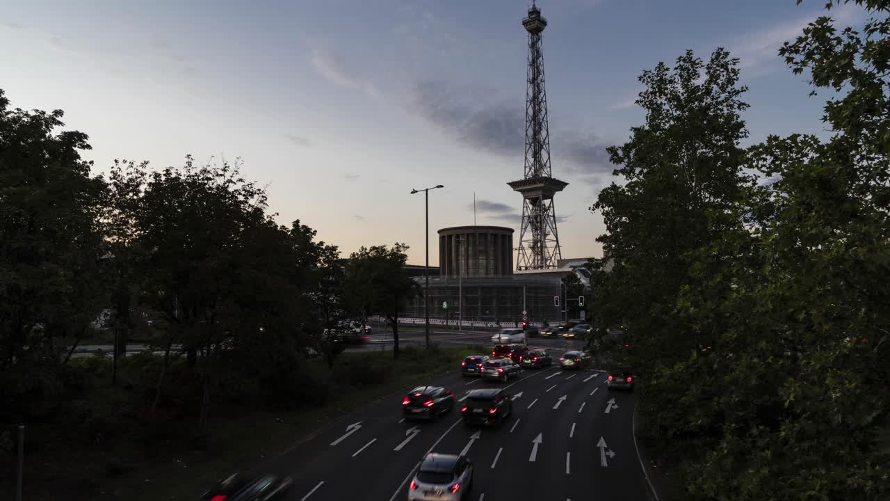 Timelapse of Cars leaving highway near Funkturm (TV tower) in Berlin, Germany at night, crossroad with traffic light