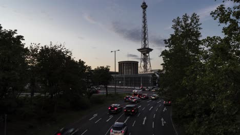 timelapse of cars leaving highway near funkturm (tv tower) in berlin, germany at night, crossroad with traffic light